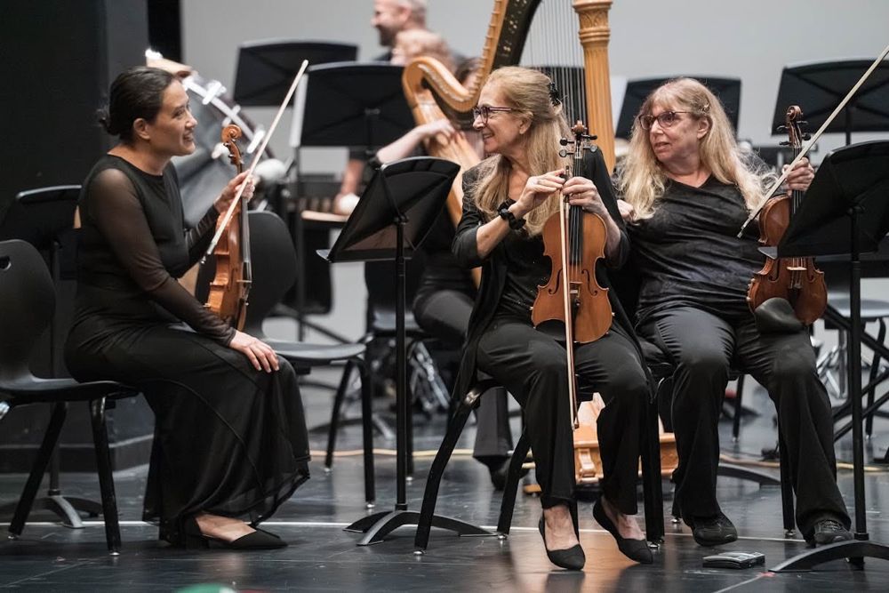 SCSO string players sharing a laugh on stage between pieces